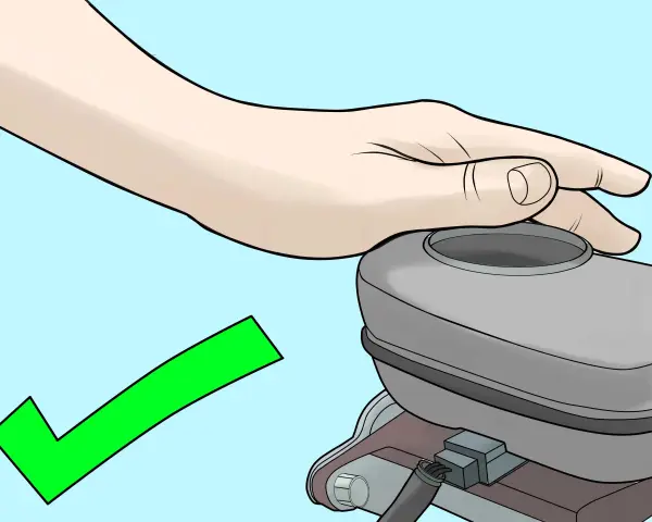 Mano che copre il serbatoio della pompa frizione, con segno di spunta verde. Procedura per come spurgare pompa frizione completata con successo.