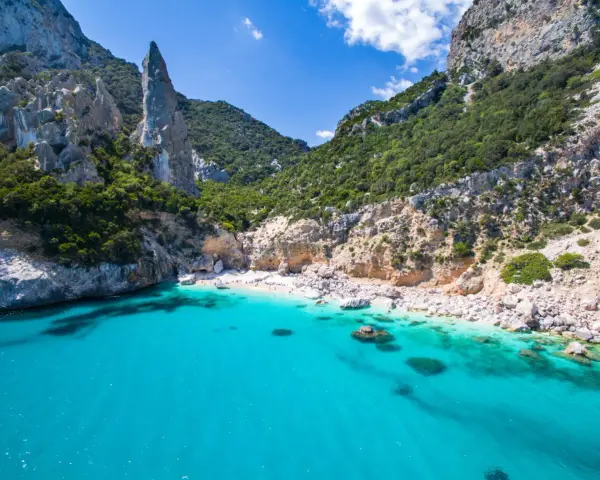 Spiaggia rosa di Budoni, incastonata tra scogliere imponenti e un mare cristallino.