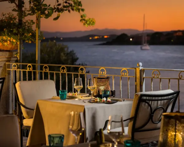 Tavola apparecchiata con vista sul golfo al tramonto. Atmosfera romantica in uno dei ristoranti di Golfo Aranci.
