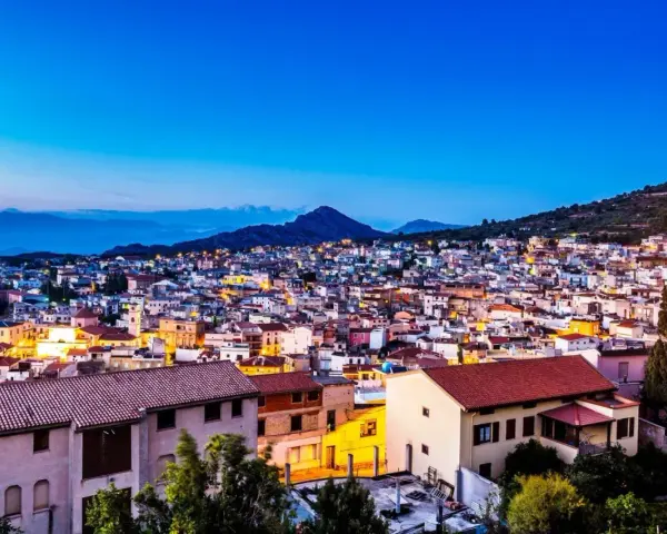 Vista serale di Cala Gonone, con luci accese tra le case. Perfetto per scoprire cosa fare la sera.