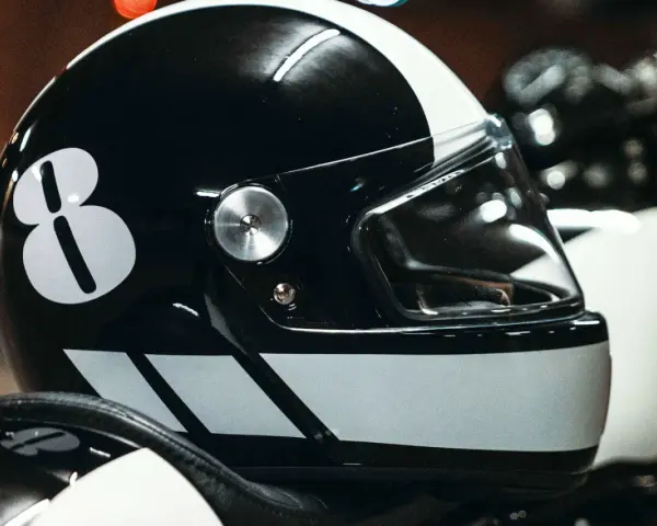 Casco nero con numero 8 bianco e strisce. Per sapere come non far appannare la visiera del casco, guarda questo dettaglio.