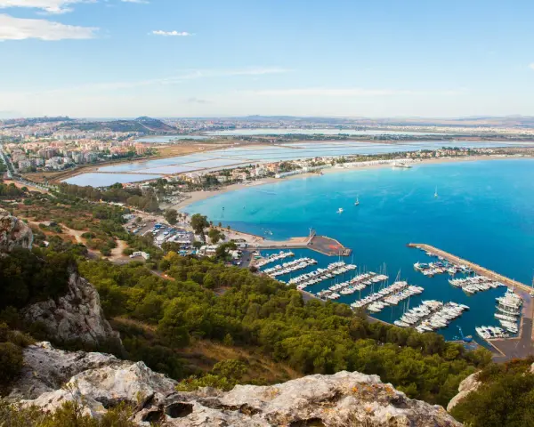 Vista panoramica del **percorso** verso la **Sella del Diavolo**, con il porto turistico, la spiaggia e la città sullo sfondo.