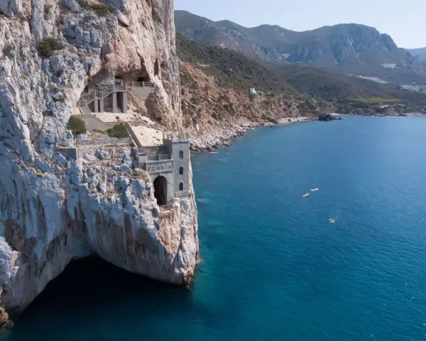 Porto Flavia, un'antica miniera a picco sul mare. Come arrivare: in auto o con tour in barca per ammirare la costa.
