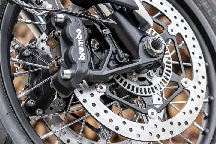 Primo piano della pinza freno Brembo e del disco forato, dettagli per la sostituzione pastiglie freni moto.