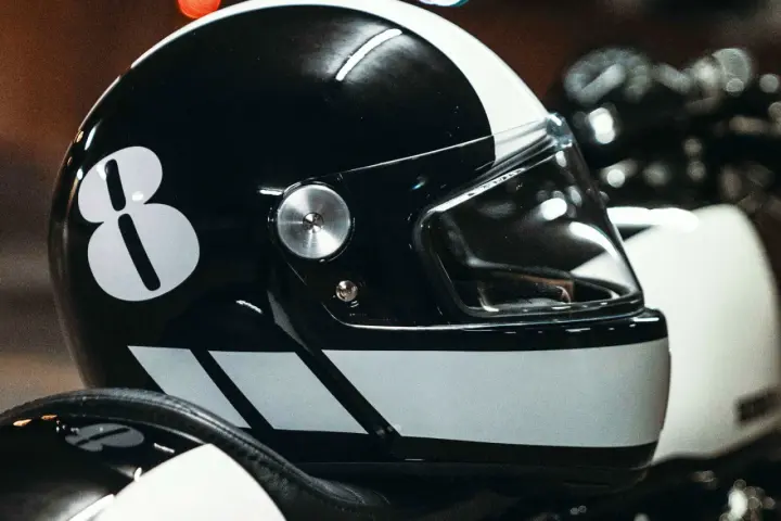 Casco nero con numero 8 bianco e strisce. Per sapere come non far appannare la visiera del casco, guarda questo dettaglio.