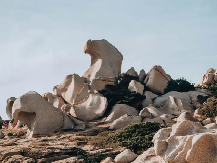 Formazioni rocciose scolpite dal vento nella Valle della Luna, Santa Teresa di Gallura. Un paesaggio lunare con rocce levigate e macchia mediterranea.