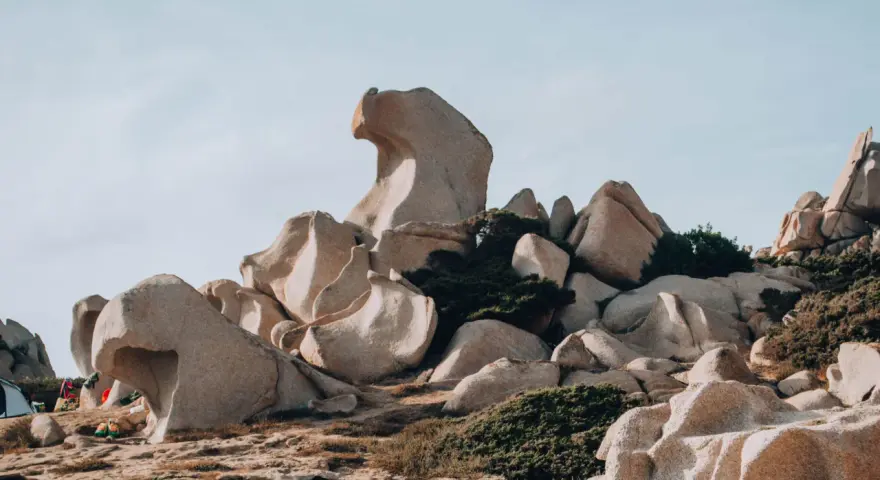 Formazioni rocciose scolpite dal vento nella Valle della Luna, Santa Teresa di Gallura. Un paesaggio lunare con rocce levigate e macchia mediterranea.