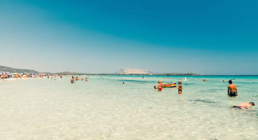 Splendida giornata al mare della Sardegna, con acque cristalline e gente che si gode il sole e il mare.