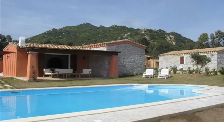 Una villa con piscina azzurra e montagne verdi sullo sfondo. Perfetta per una vacanza di relax, sa sippa.