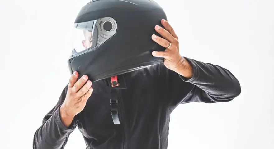 Persona indossa un casco integrale nero, pronto per un'avventura in moto.