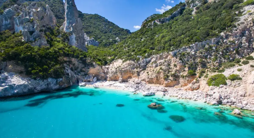Spiaggia rosa di Budoni, incastonata tra scogliere imponenti e un mare cristallino.