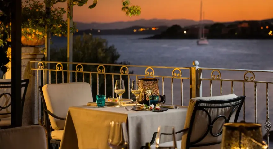 Tavola apparecchiata con vista sul golfo al tramonto. Atmosfera romantica in uno dei ristoranti di Golfo Aranci.