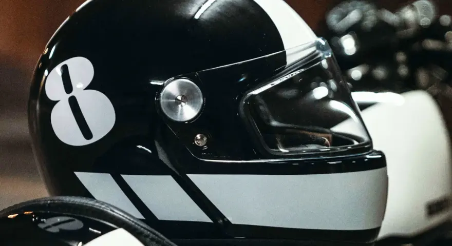 Casco nero con numero 8 bianco e strisce. Per sapere come non far appannare la visiera del casco, guarda questo dettaglio.