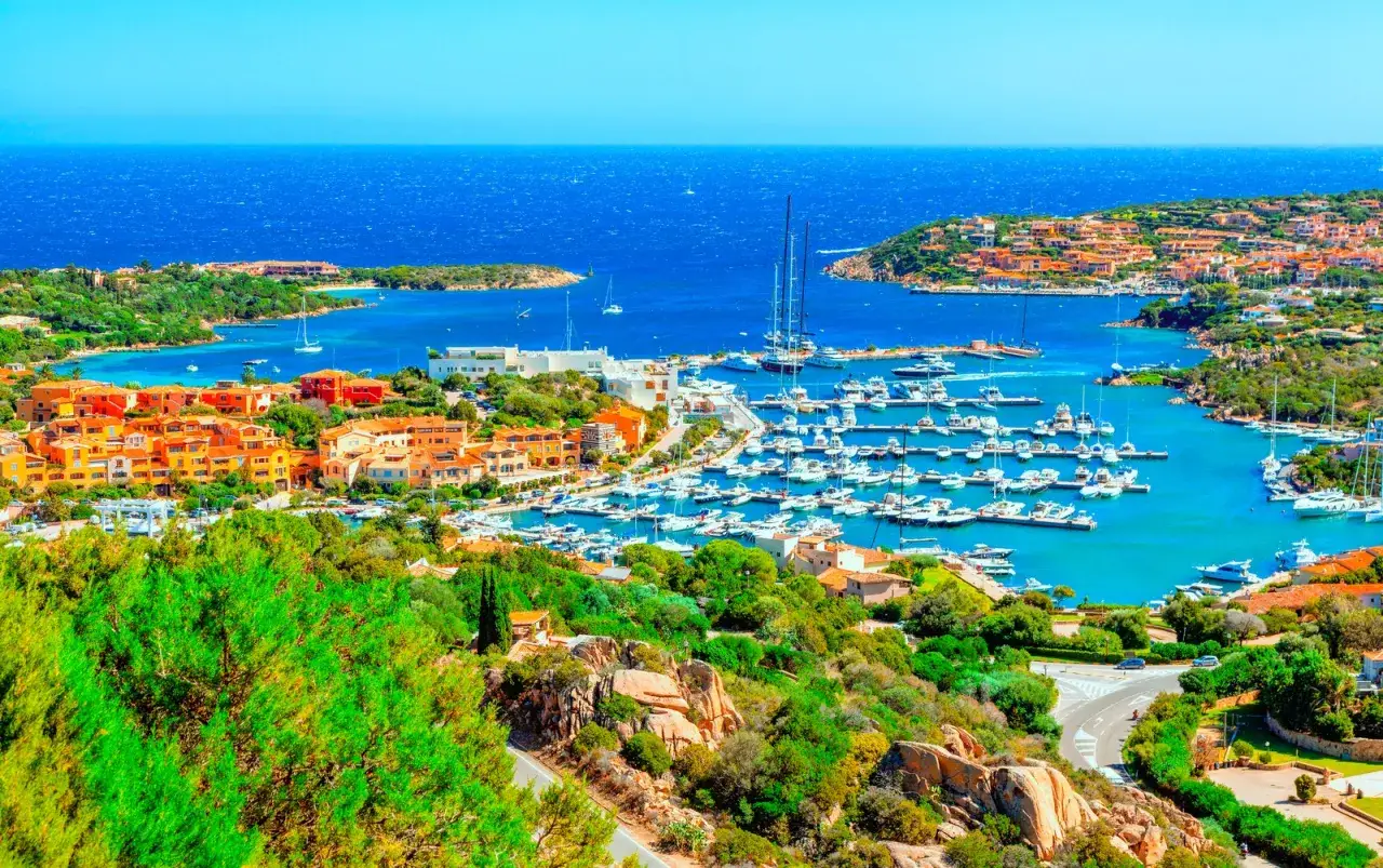 Porto Cervo, sulla Costa Smeralda, con il suo porto pieno di yacht e le case colorate che si affacciano sul mare cristallino.
