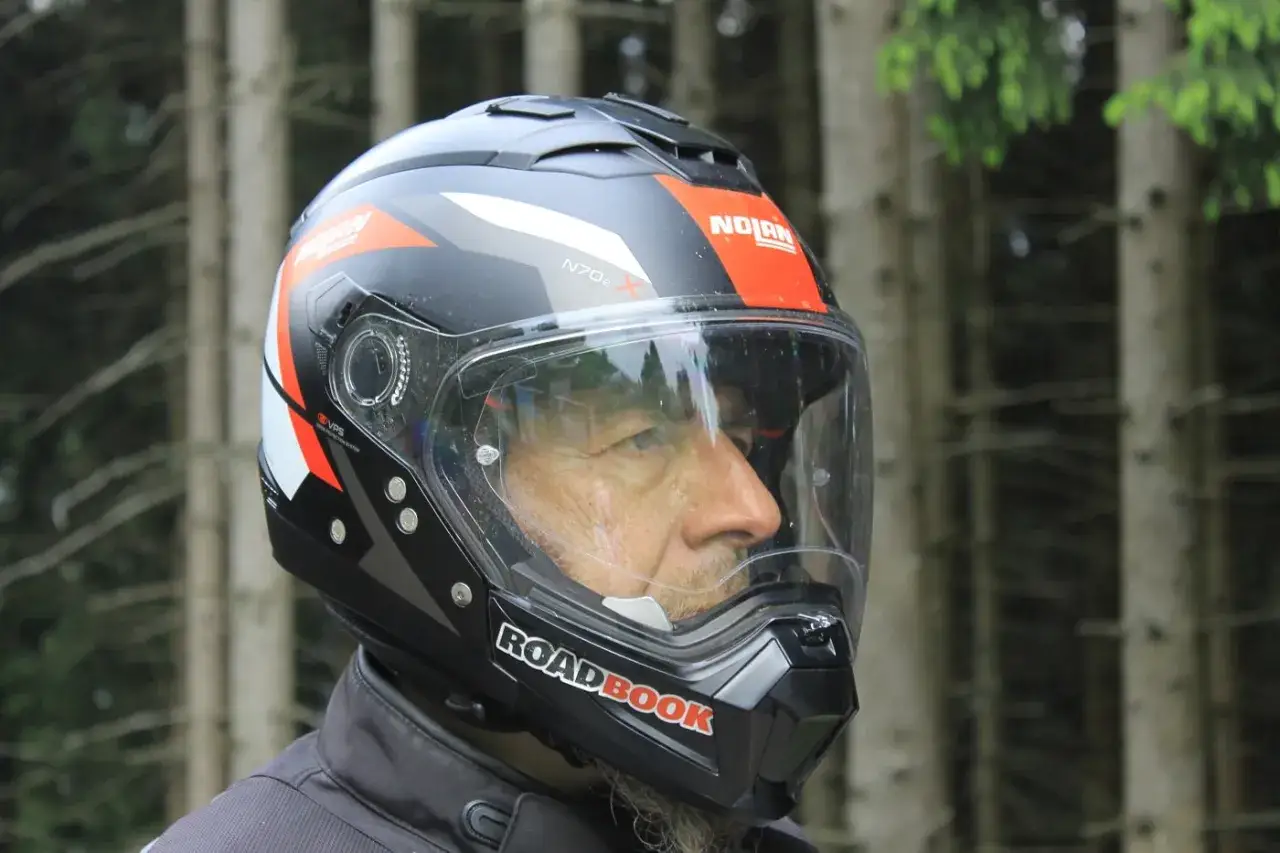 Uomo con casco integrale Nolan N70-2 X, pronto per un'avventura su strada.