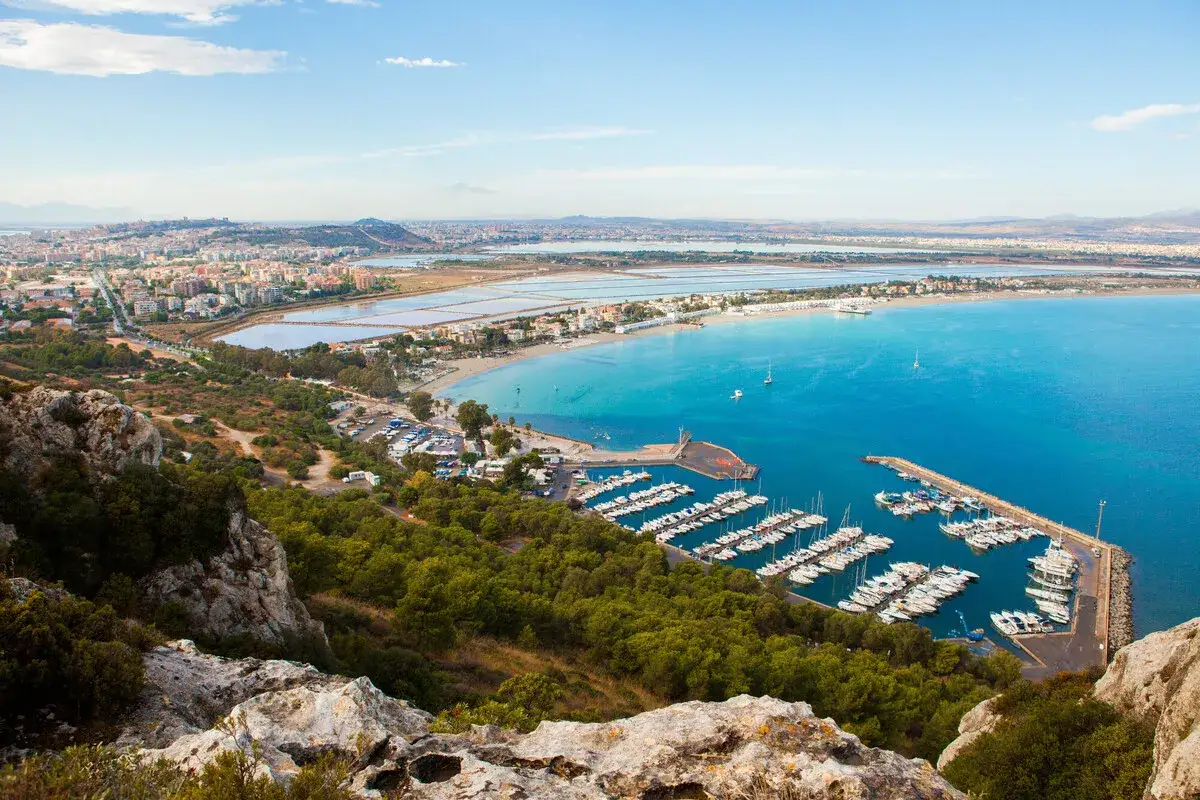 Vista panoramica del percorso della Sella del Diavolo, con il porto turistico, la spiaggia e la città sullo sfondo.
