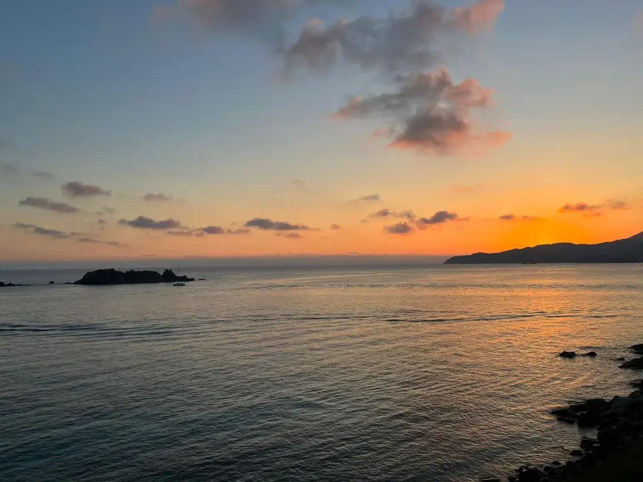 Un tramonto mozzafiato a Villasimius, con il sole che cala dietro le colline e tinge il mare di arancione. Un luogo perfetto dove vedere il tramonto.
