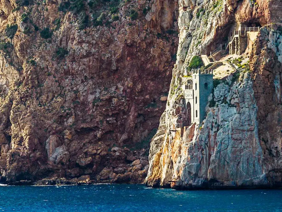 Porto Flavia, un'antica miniera a picco sul mare. Per raggiungerla, si sale una scalinata scavata nella roccia.