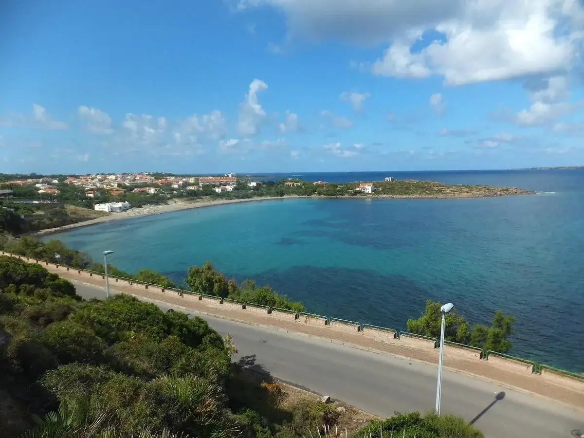 Vista panoramica del calasetta centro storico con mare cristallino, spiaggia e case colorate.
